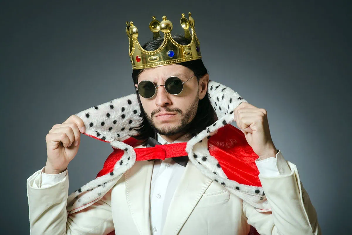 a man is dressed up both like a businessman and a king.