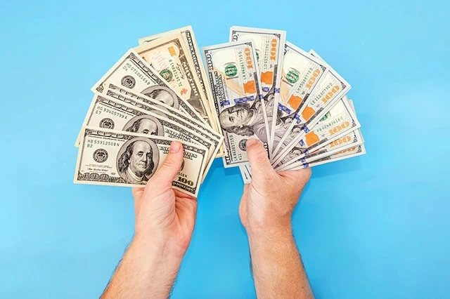 ๐ฐ Powerful Fundrise Alternatives for Smart Real Estate Crowdfunding 17 a pair of hands fan out a bunch of old and new hundred dollar bills.