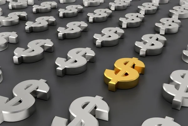 a bunch of 3d silver dollar signs and one 3d gold dollar sign.