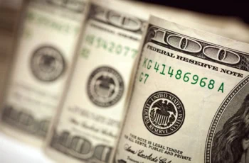 three rolls of hundred dollar bills side by side.