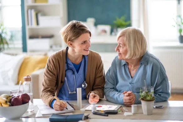 Caregiver or healthcare worker with senior woman patient, explaining how to use litmus paper