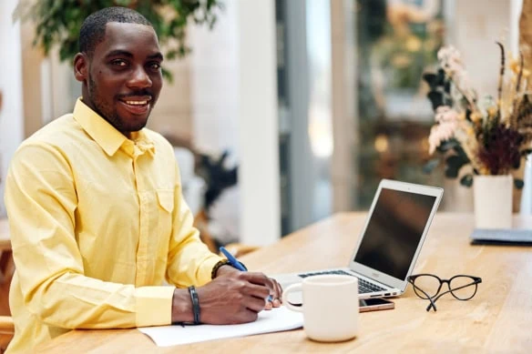 Young professional African American male sitting at a desk with a laptop.