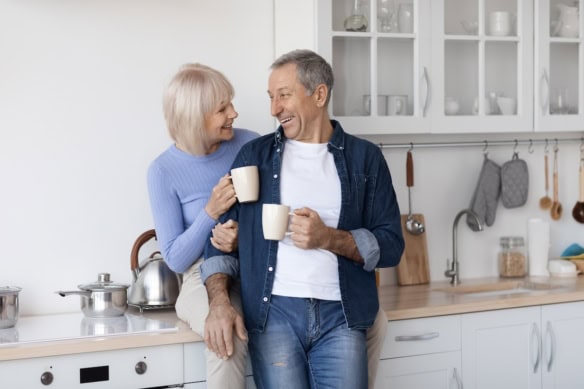 Cheerful elderly spouses enjoying time together, drinking coffee