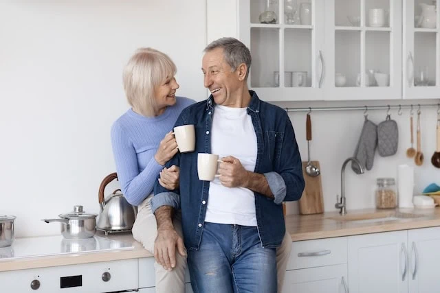 Cheerful elderly spouses enjoying time together, drinking coffee