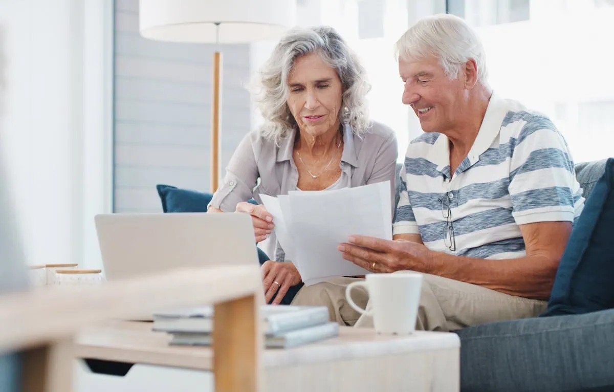 The GPO Rollercoaster: Why Washington Keeps Flip-Flopping on The Government Pension Offset 2 Seeing positive returns on their pension fund. a senior couple going through paperwork on the sofa at home.