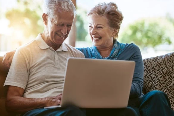 Keeping up with modern times. a happy senior couple using a laptop together on the sofa at home.