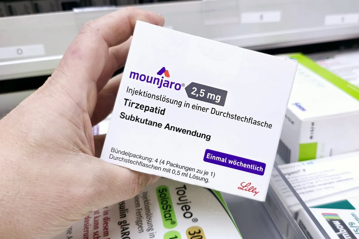 a pharmacist holds a box of mounjaro by eli lilly.