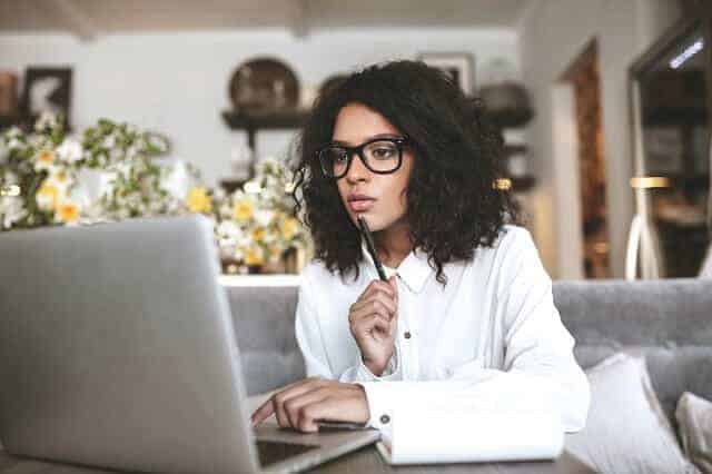 engaged woman examining information on laptop