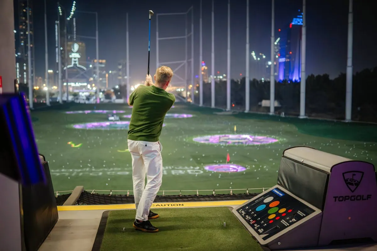 Our 12-Stock 'Starter Set' for Dividend Investors 15 a man takes a swing at a topgolf facility in Dubai.
