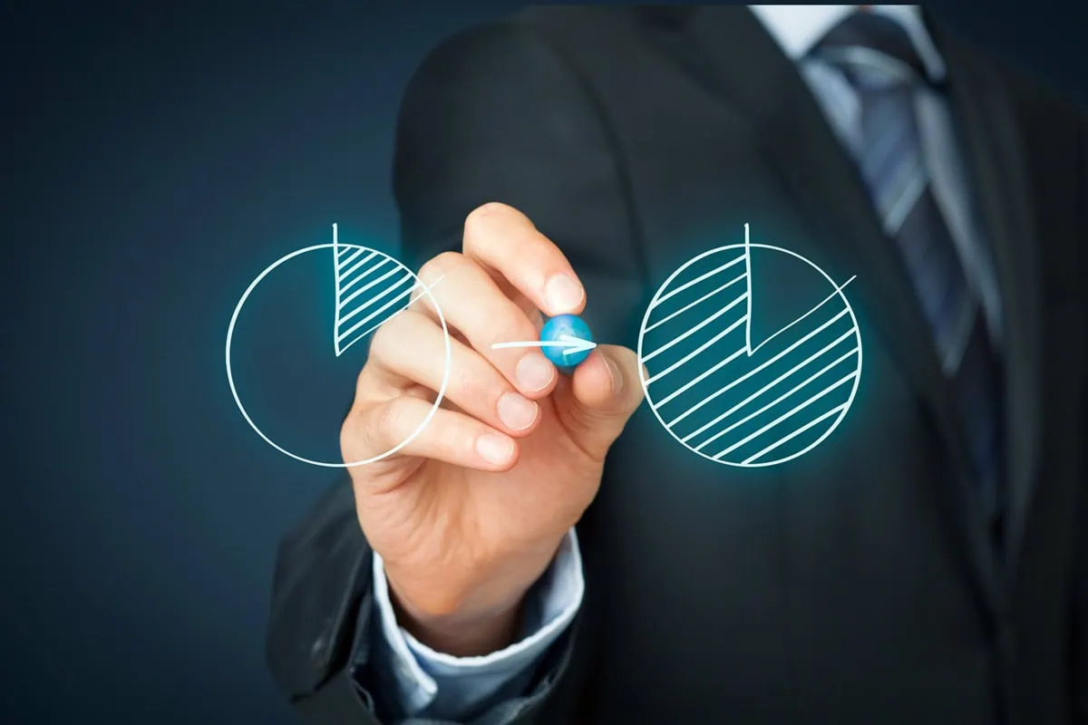 a business person draws two virtual pie charts.