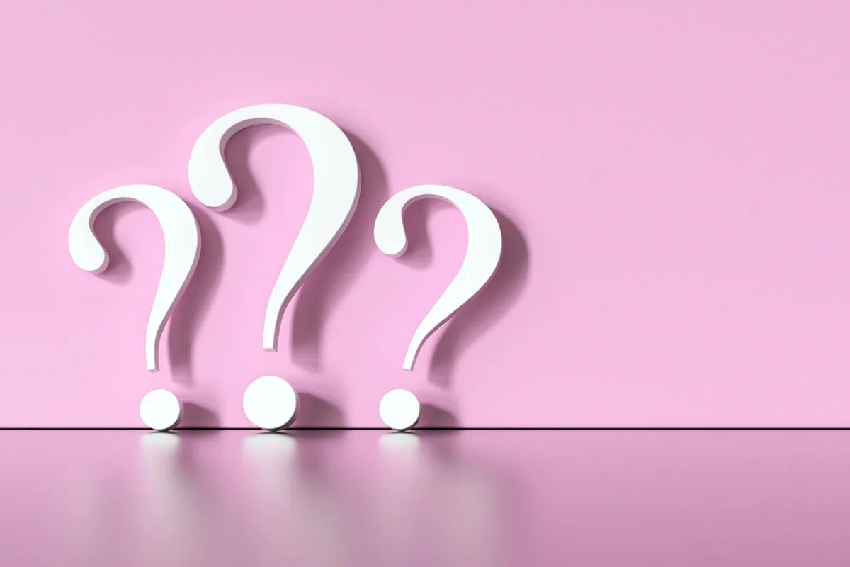 white question marks against a pink background.