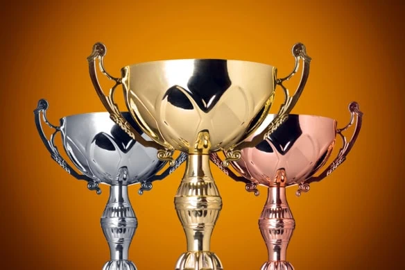 gold silver and bronze trophies against an orange background.