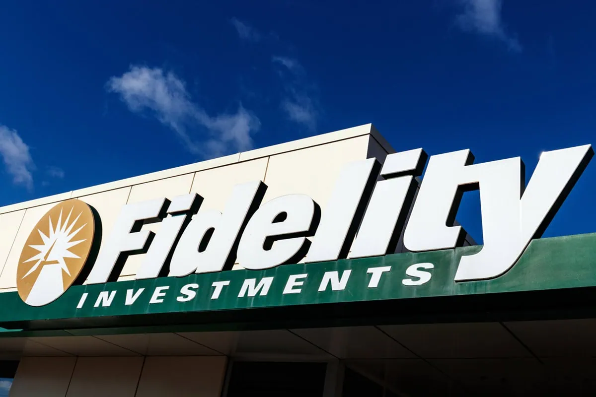 a fidelity investment's building sign up against a dark blue sky.
