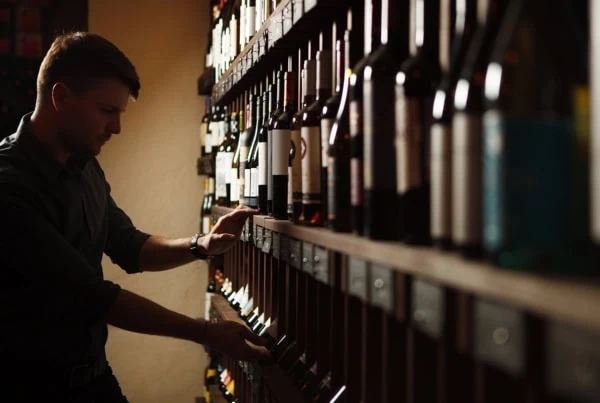 a sommelier looks for a bottle of wine.