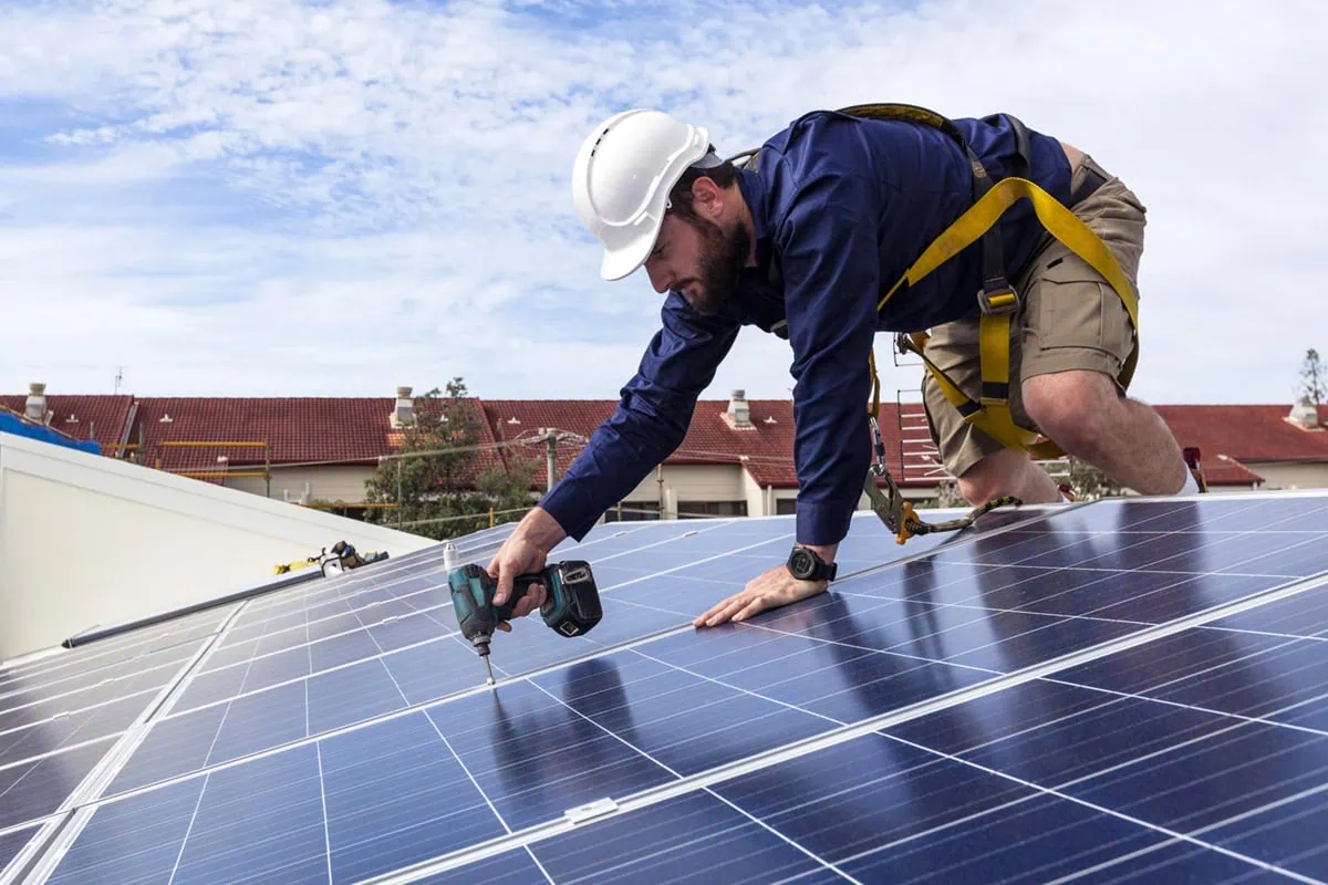 a technician installs a solar panel.