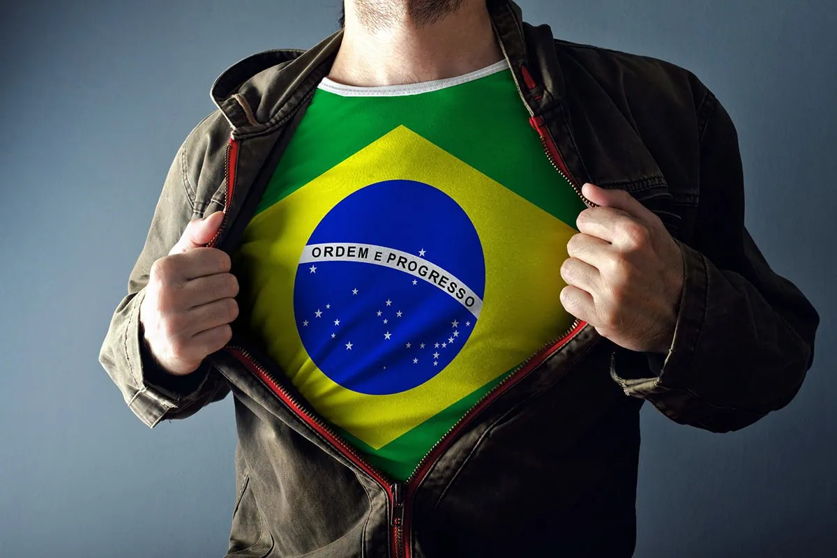 Man stretching jacket to reveal shirt with Brazil flag.