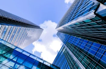 a vertical view of buildings from ground level against a blue sky.