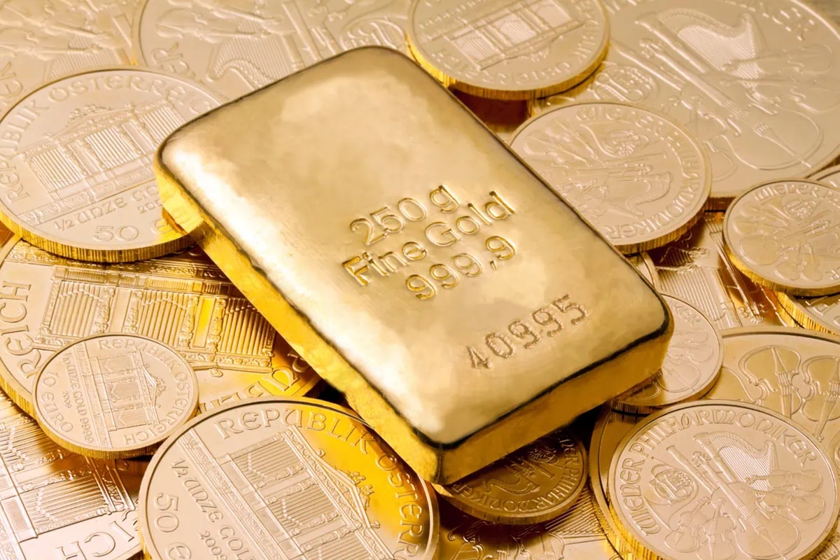 a small gold bar lying on gold coins.