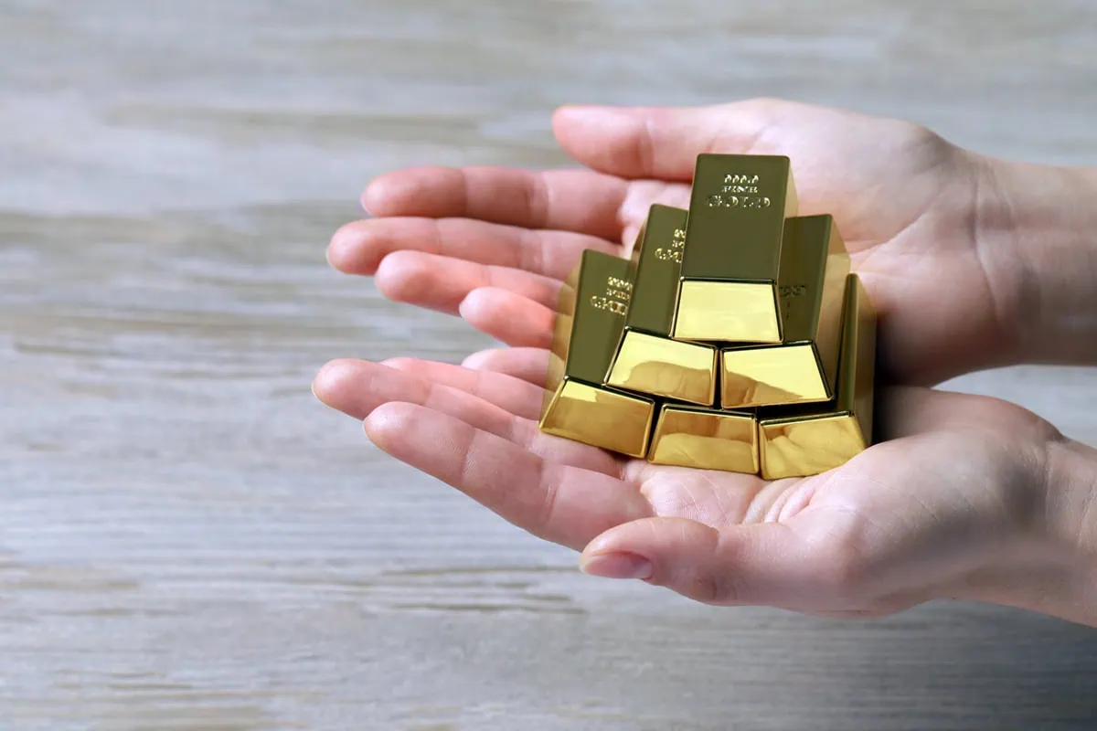 These 7 Gold ETFs Are Soaring as Gold Eclipses $4,000 6 a woman holding miniature gold bars in her hands.