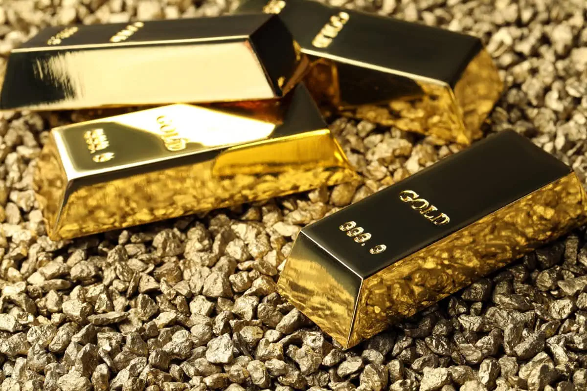 gold bars sitting on gravel.