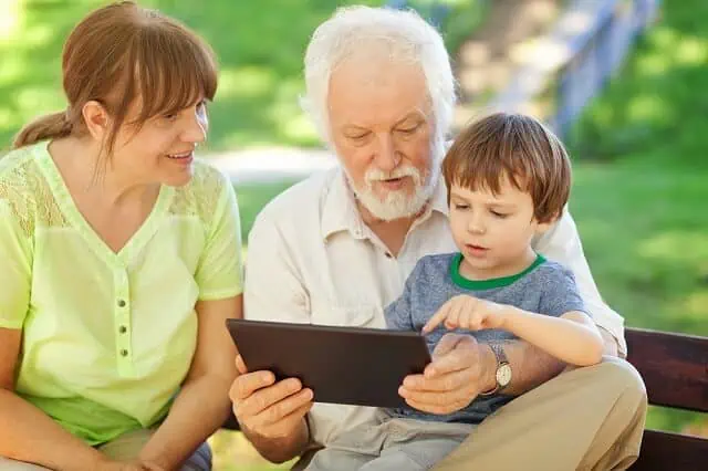 grandparents with grand child on tablet medium