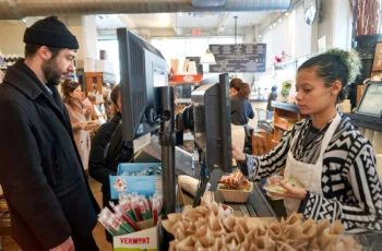 A grocery store worker helps a customer check out.