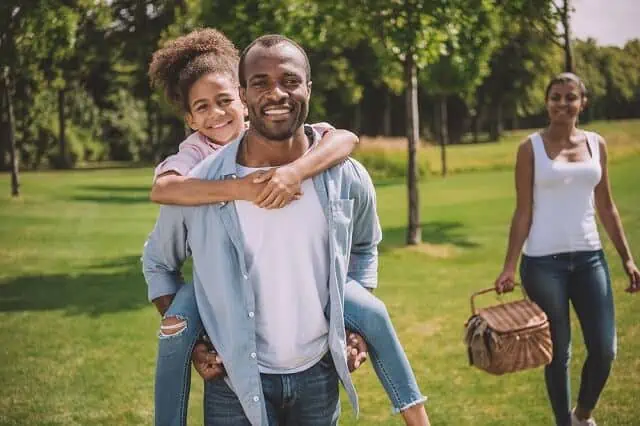 happy family in the park piggyback ride