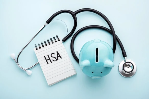 a piggy bank a stethoscope and a tablet that says H S A which stands for health savings account.
