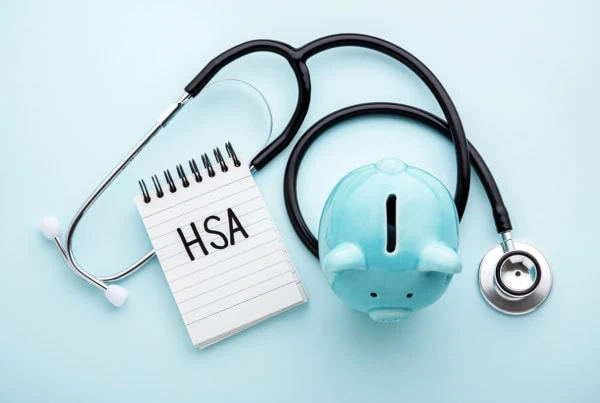 a piggy bank a stethoscope and a tablet that says H S A which stands for health savings account.