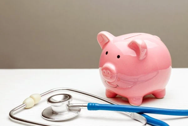 a piggy bank next to a stethoscope.