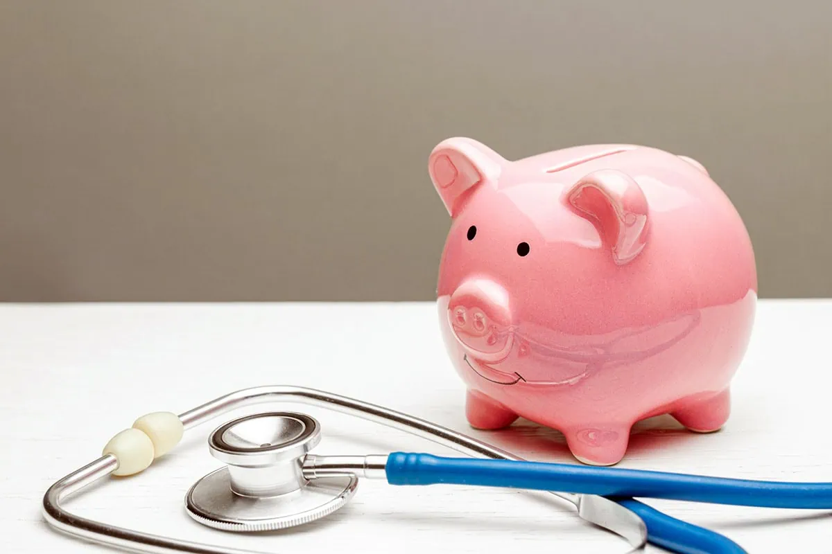 a piggy bank next to a stethoscope.