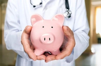 a doctor holds a piggy bank.