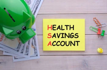 a green piggy bank sits to the left of a post-it note that says health savings account.