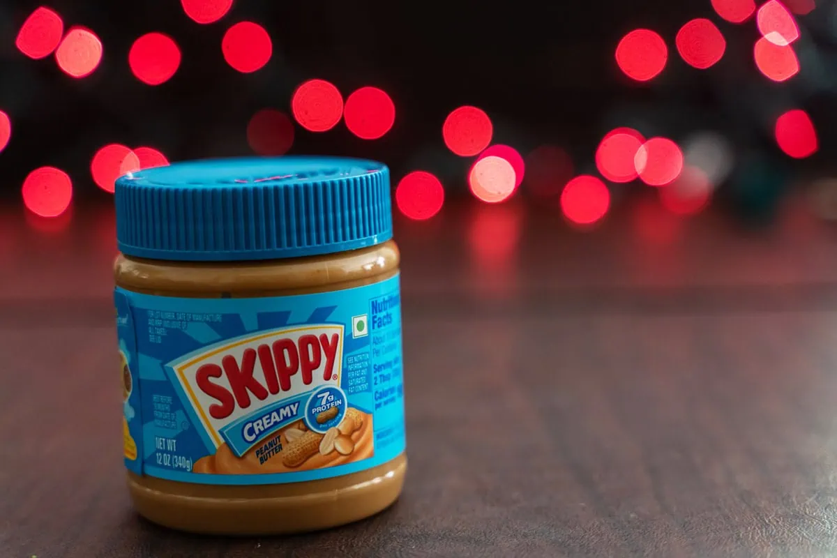 a jar of skippy peanut butter sits on a table.