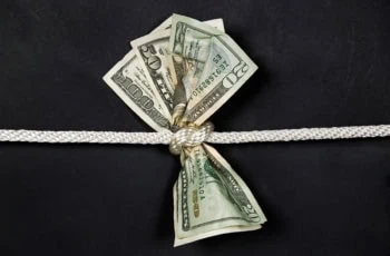 a rope tightens around 20 50 and 100 dollar bills.
