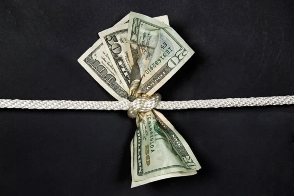 a rope tightens around 20 50 and 100 dollar bills.