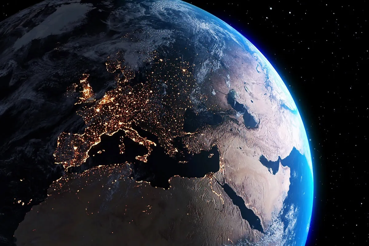 planet earth focused on europe at night shown from space with surface level lights visible.