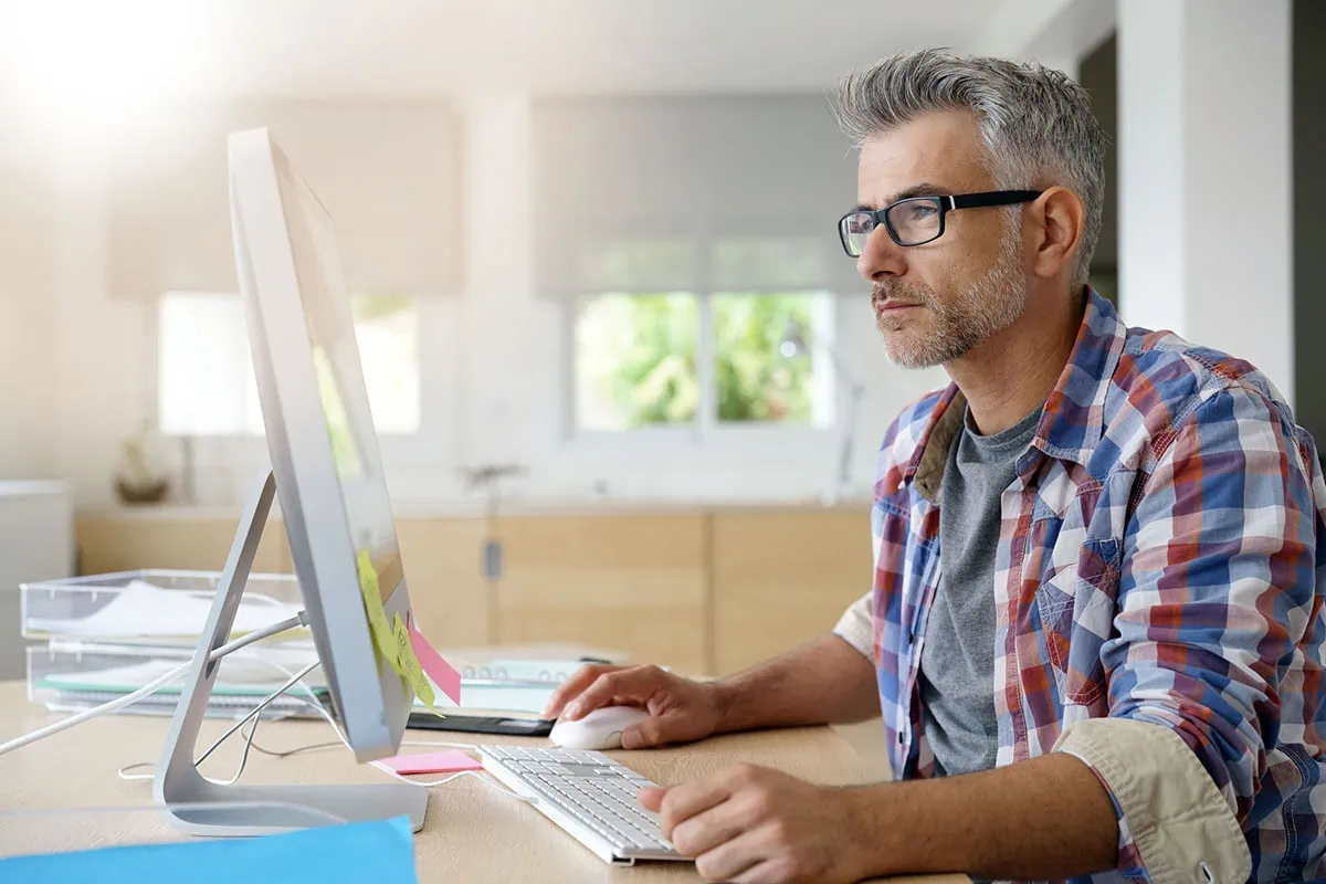 a middle-aged man uses the computer.