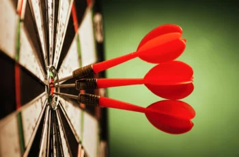 three darts in the bullseye of a target.