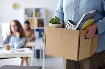 a man packs up a box and leaves his office. 1200