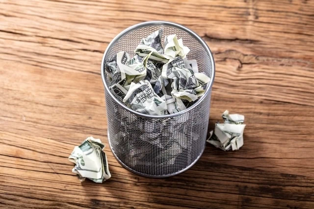 junk consumer fees dollars trash bin