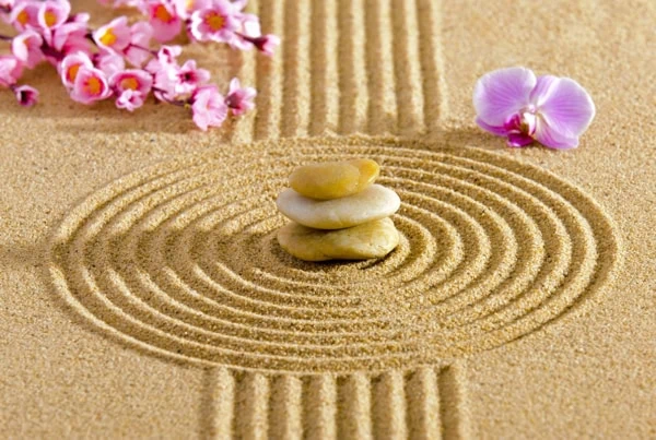 a japanese zen guarden with stacked rocks and lotus blossoms.