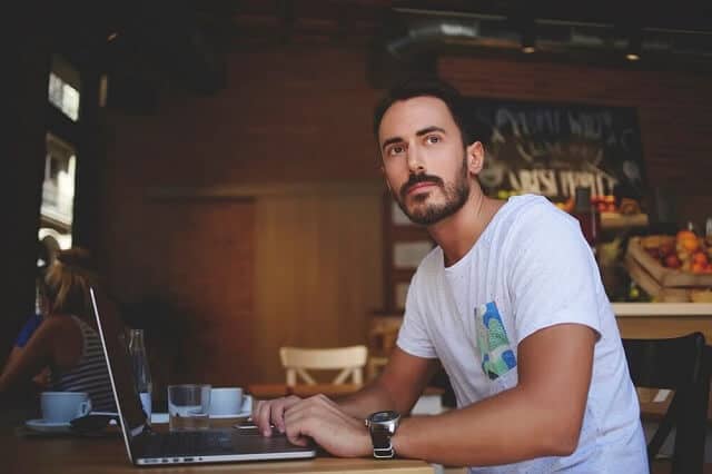 man sitting at laptop thinking medium