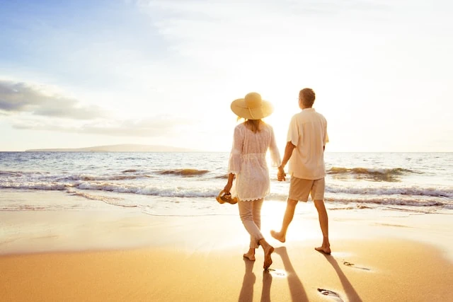 Mature Couple Walking on the Beach at Sunset