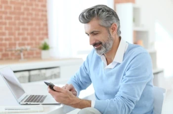 man looking at his phone and computer