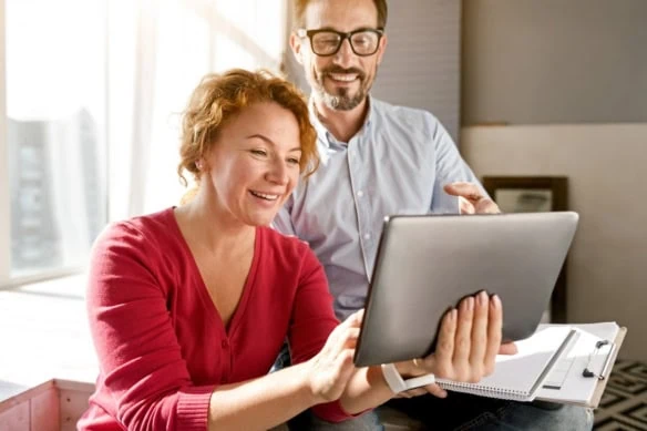 middle aged couple looking at ipad happily