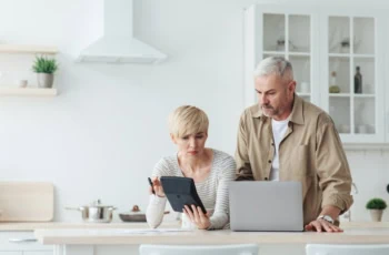 middle-aged couple looking at laptop and calculator