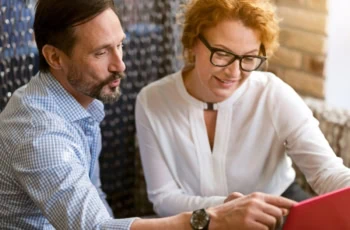 middle-aged coupled looking at laptop screen together gen x