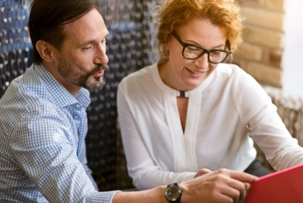 middle-aged coupled looking at laptop screen together gen x
