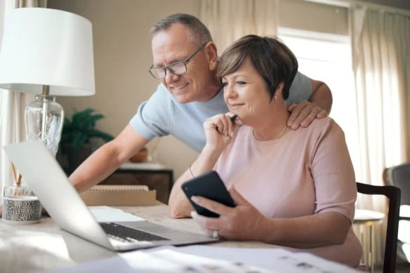 middle-aged couple looking at laptop together liking what they are seeing